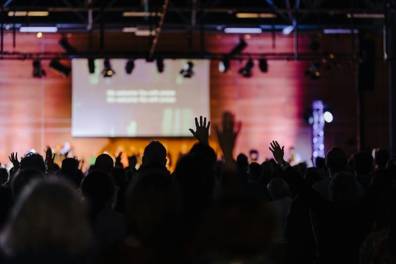 blurred scene of worship with no distractions as church presentation software displays worship media and lyrics on screen