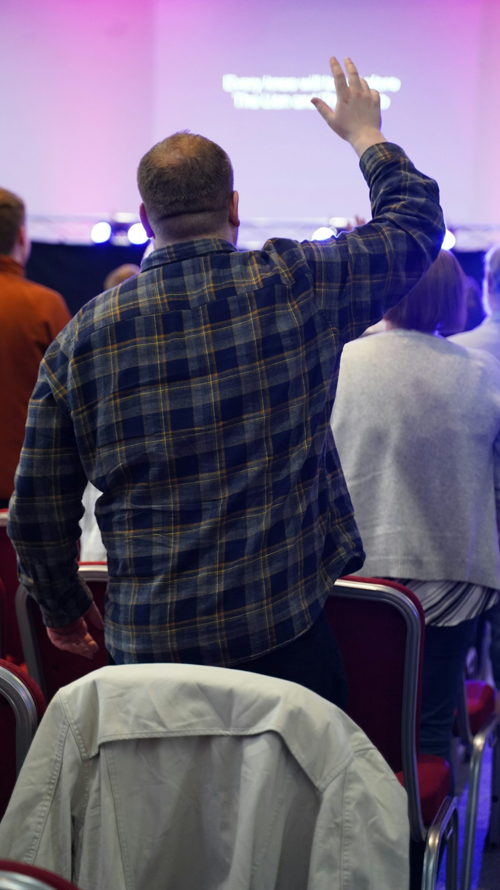from hymnals to screens older man worshipping with lyrics on screen